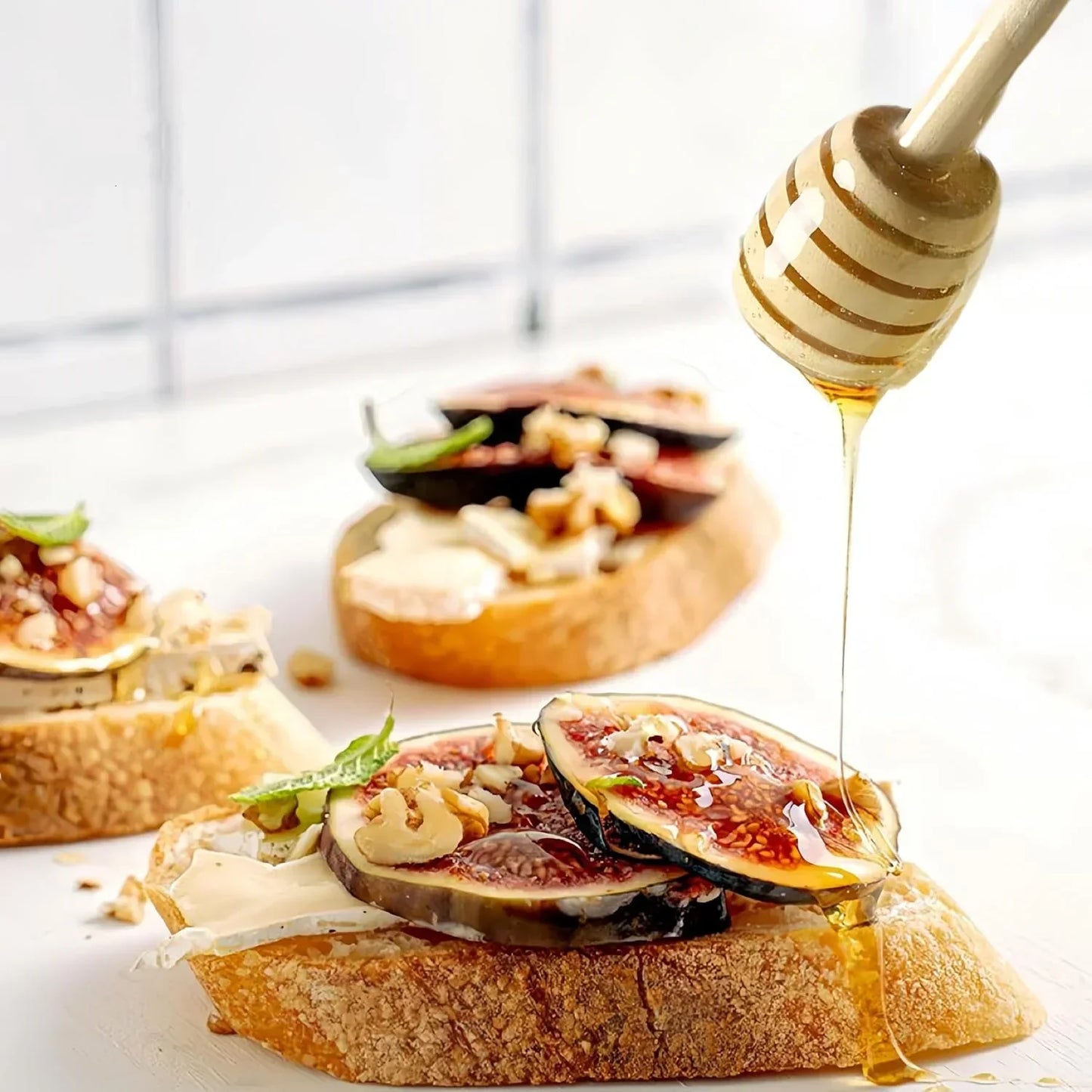 Honey drizzled over fig and cheese crostini with walnuts on rustic bread