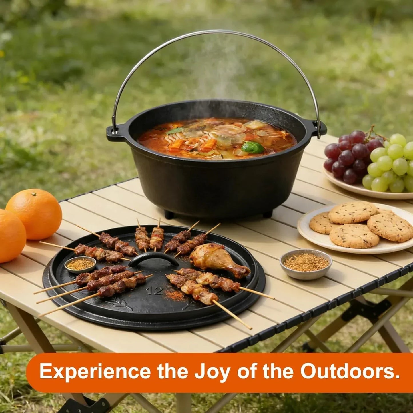 Cast iron Dutch oven and grill with skewers, grapes, cookies, and oranges on outdoor table