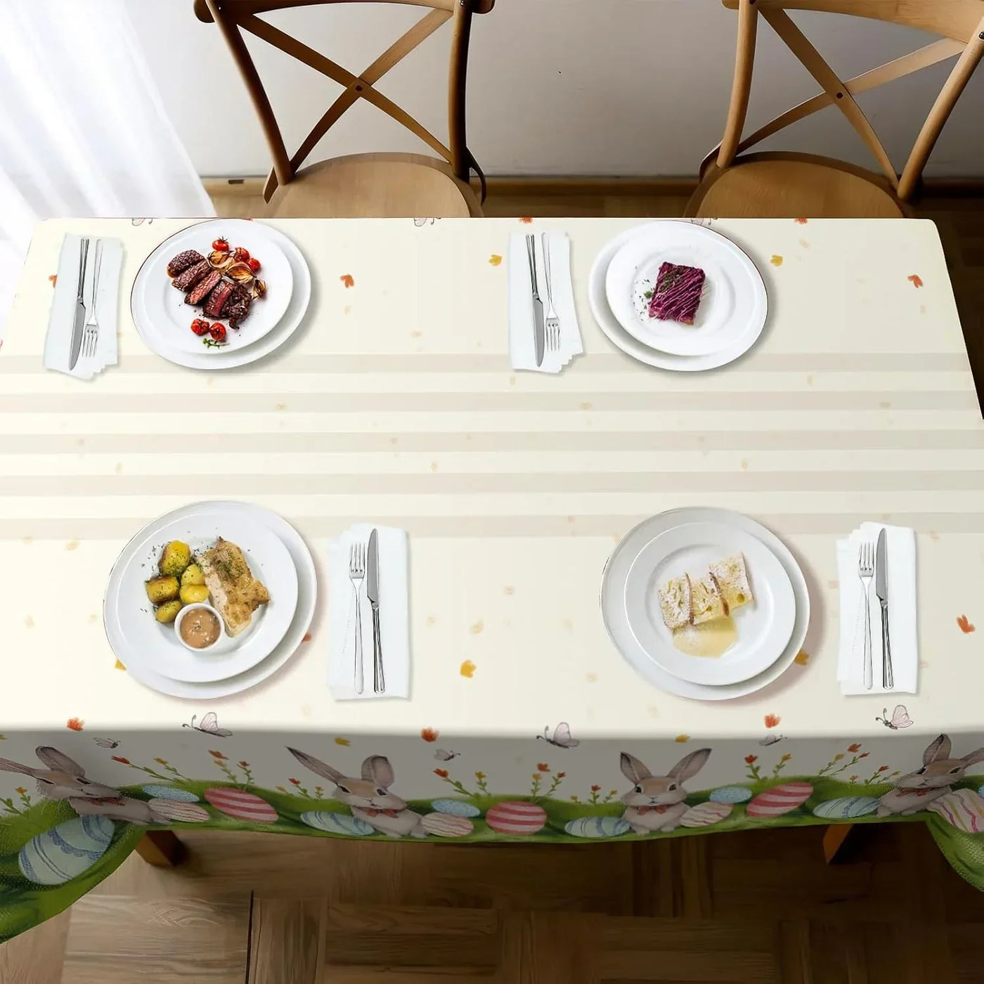 Easter-themed tablecloth with bunnies and eggs, set for four with plates, cutlery, and meals