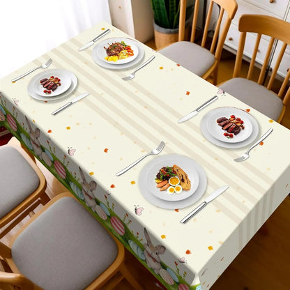 Easter-themed tablecloth with bunnies, eggs, and stripes, set for dining with plates and cutlery