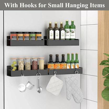 Wall-mounted kitchen shelves with hooks, holding spices, oil bottles, measuring cups, and oven mitts.