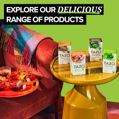 Tazo organic tea boxes and brewed tea cups on colorful tables beside a cozy sofa with plaid blanket