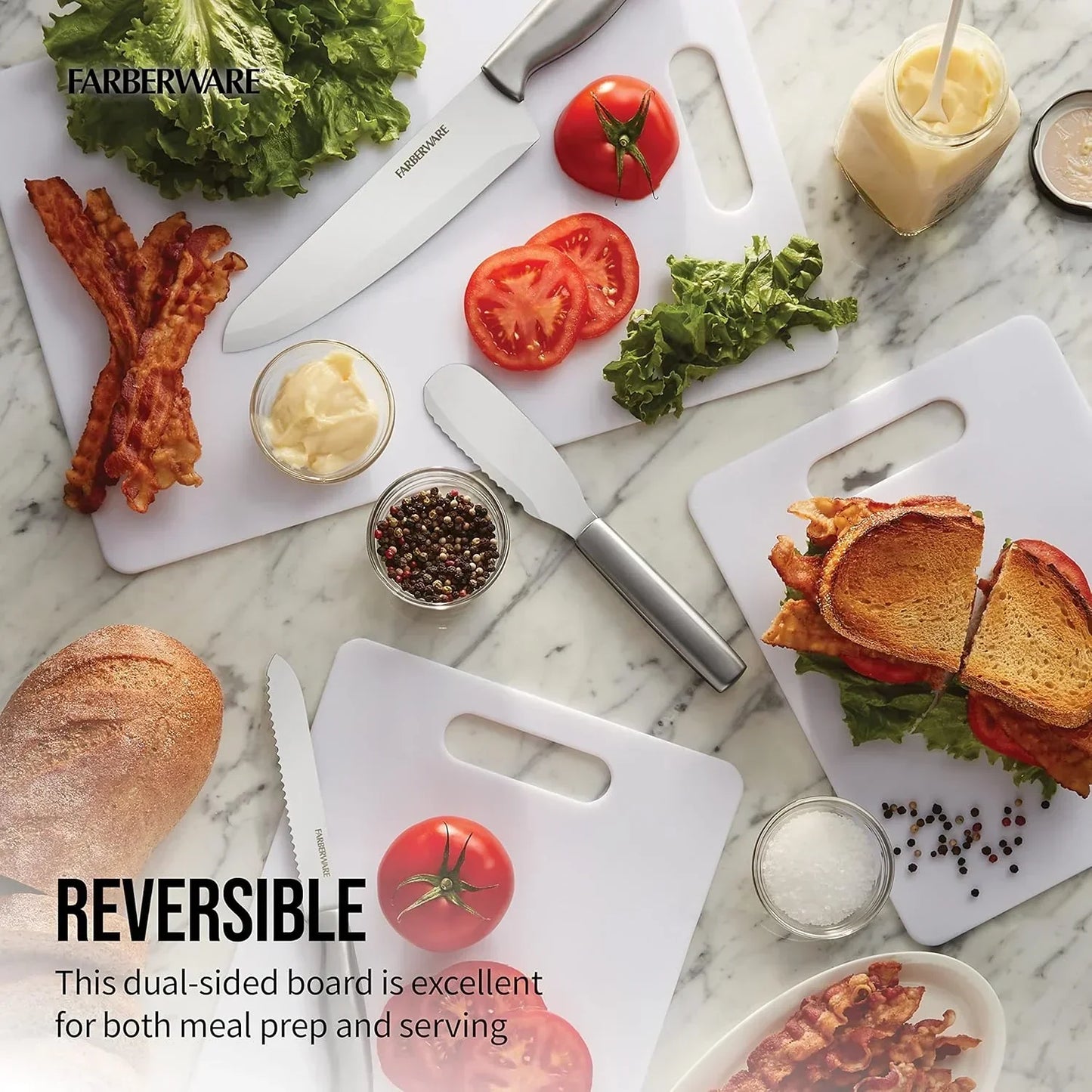 Farberware reversible cutting boards with knives, fresh veggies, bacon, and sandwich on marble countertop