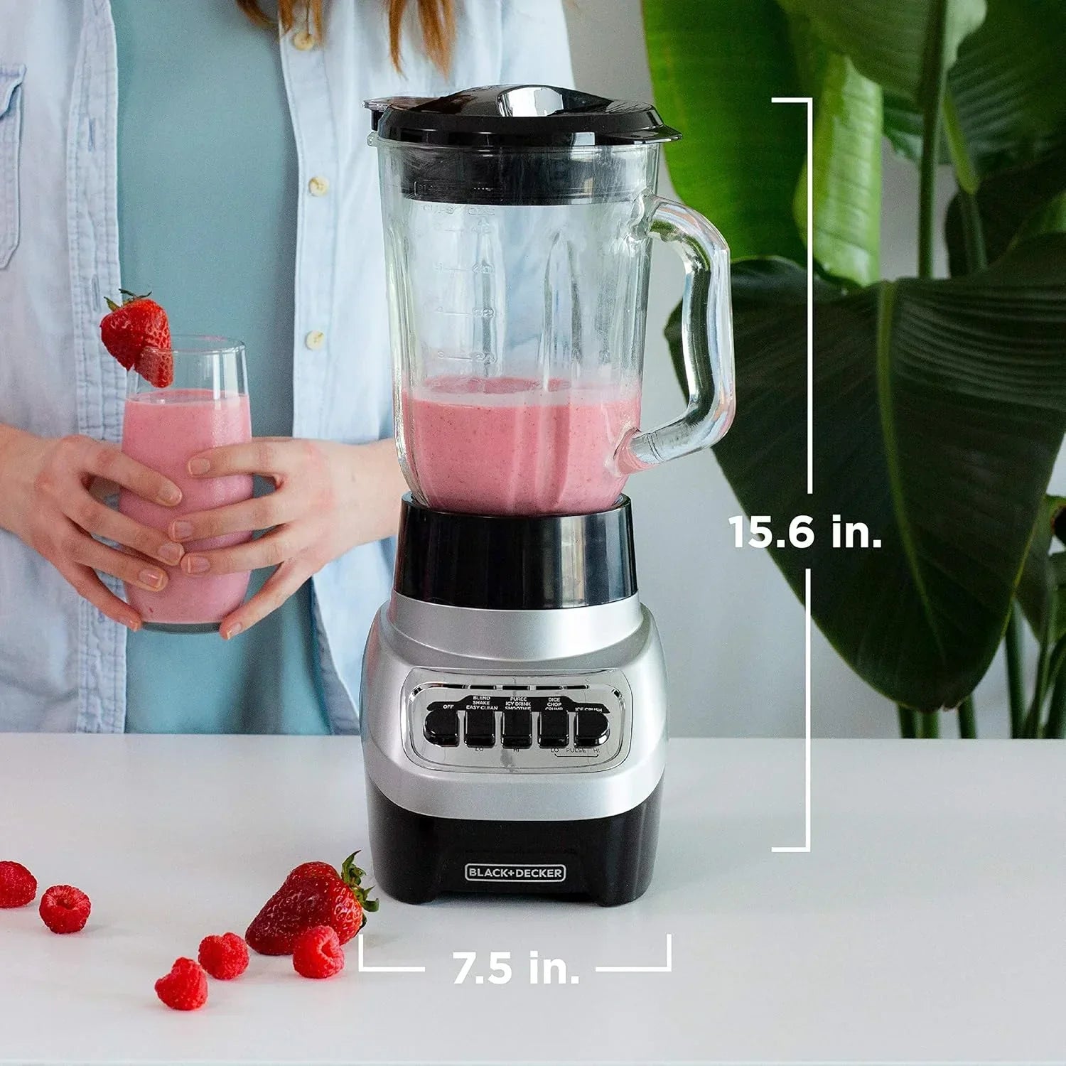 Black+Decker blender with pink smoothie, strawberries, and raspberries on white countertop
