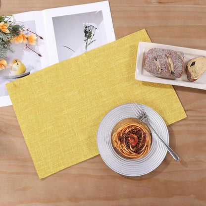 Yellow woven placemat with spaghetti plate, bread, and cookbook on wood table for kitchen dining setup