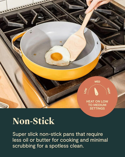 Yellow non-stick frying pan cooking sunny-side-up egg on gas stove with wooden spatula