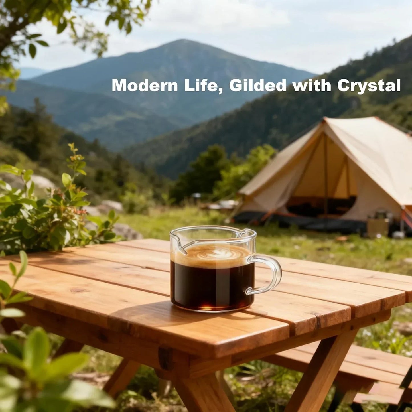 Clear glass coffee mug on wooden table outdoors with mountain view, perfect for camping or morning brew.