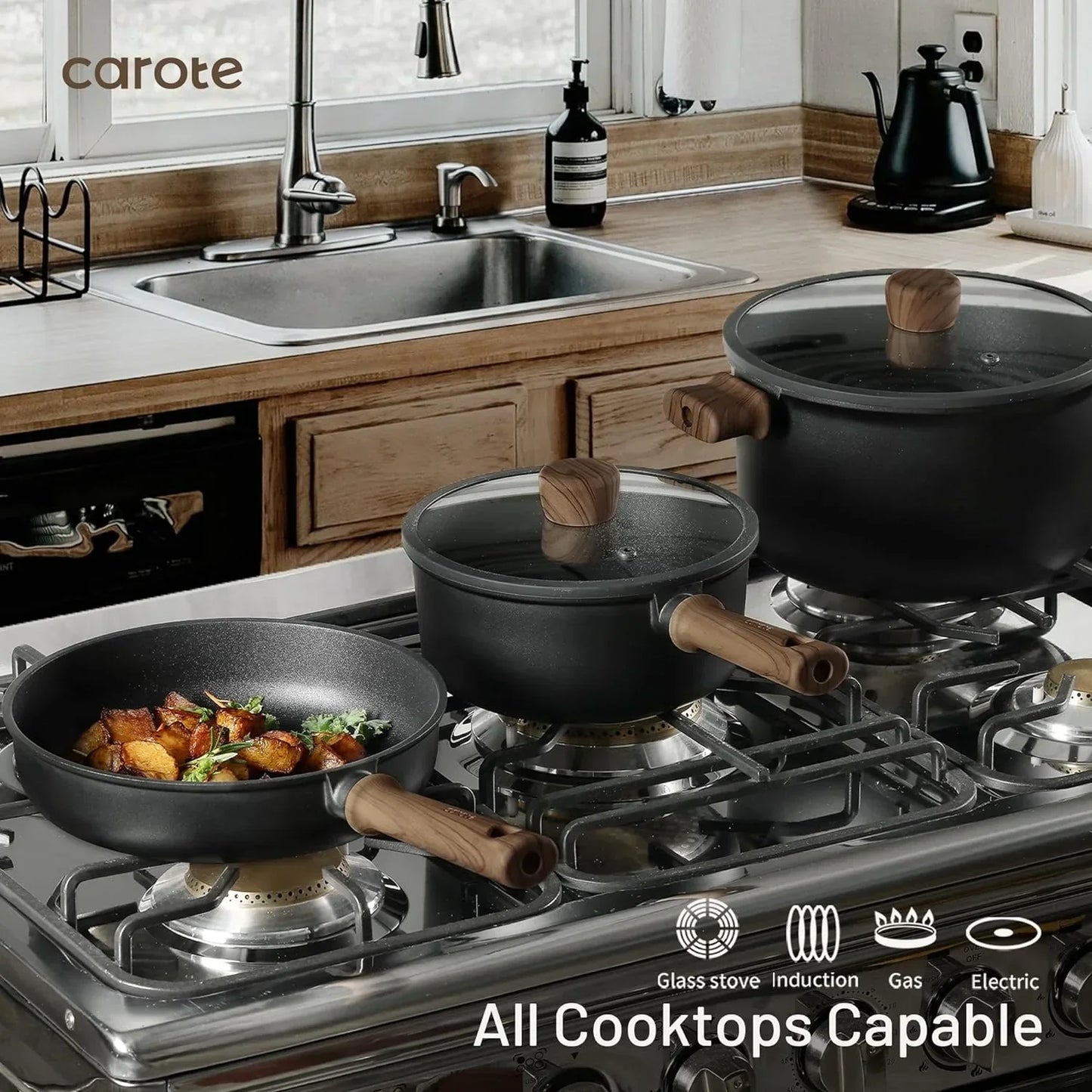 Black nonstick cookware set with wooden handles on gas stove, all cooktops capable, frying pan with roasted potatoes