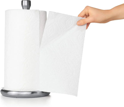 Hand pulling paper towel from stainless steel dispenser for kitchen cleanup