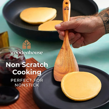 Wooden spatula flipping pancakes in nonstick pan, ideal for scratch-free cooking