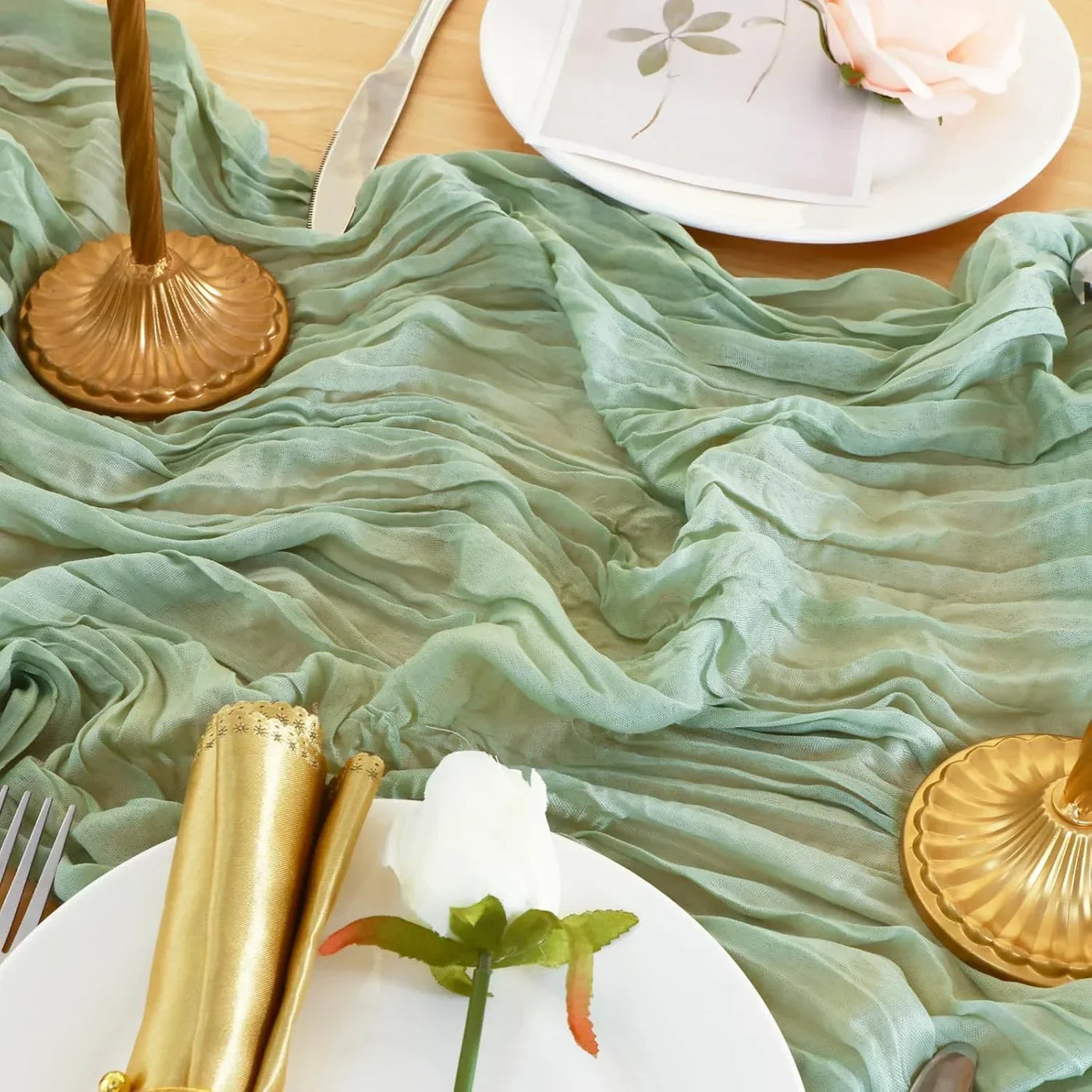 Mint green table runner with gold candlesticks and white roses for elegant dinner setup