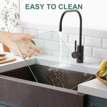 Clear glass cutting board being rinsed under faucet, easy to clean kitchen tool