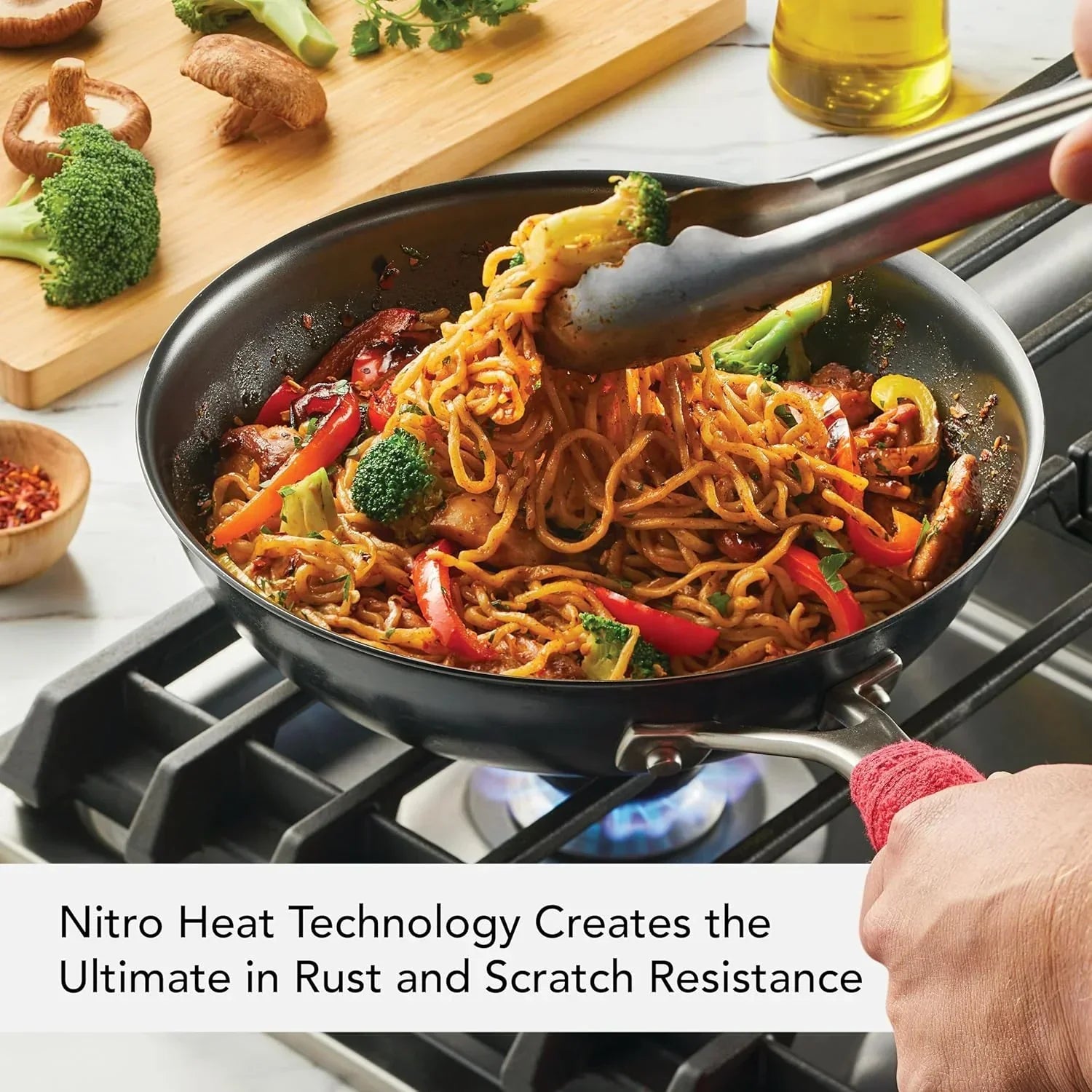 Stir-fry noodles with broccoli and peppers in a nonstick pan on stove