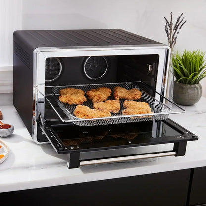 Black countertop air fryer oven with crispy chicken nuggets on mesh tray, modern kitchen appliance for healthy cooking