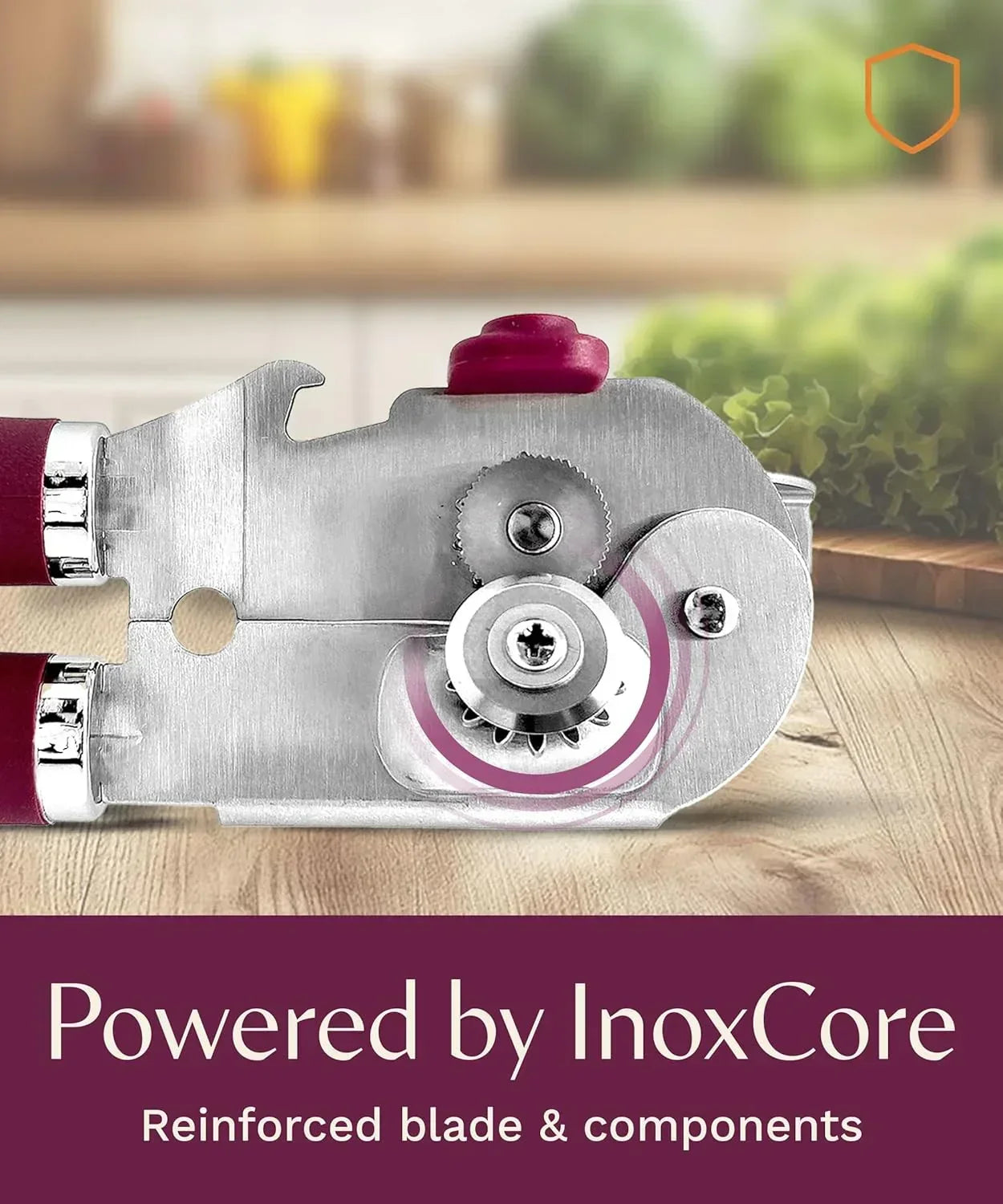 Stainless steel can opener with InoxCore reinforced blade, red handle, on wooden kitchen counter