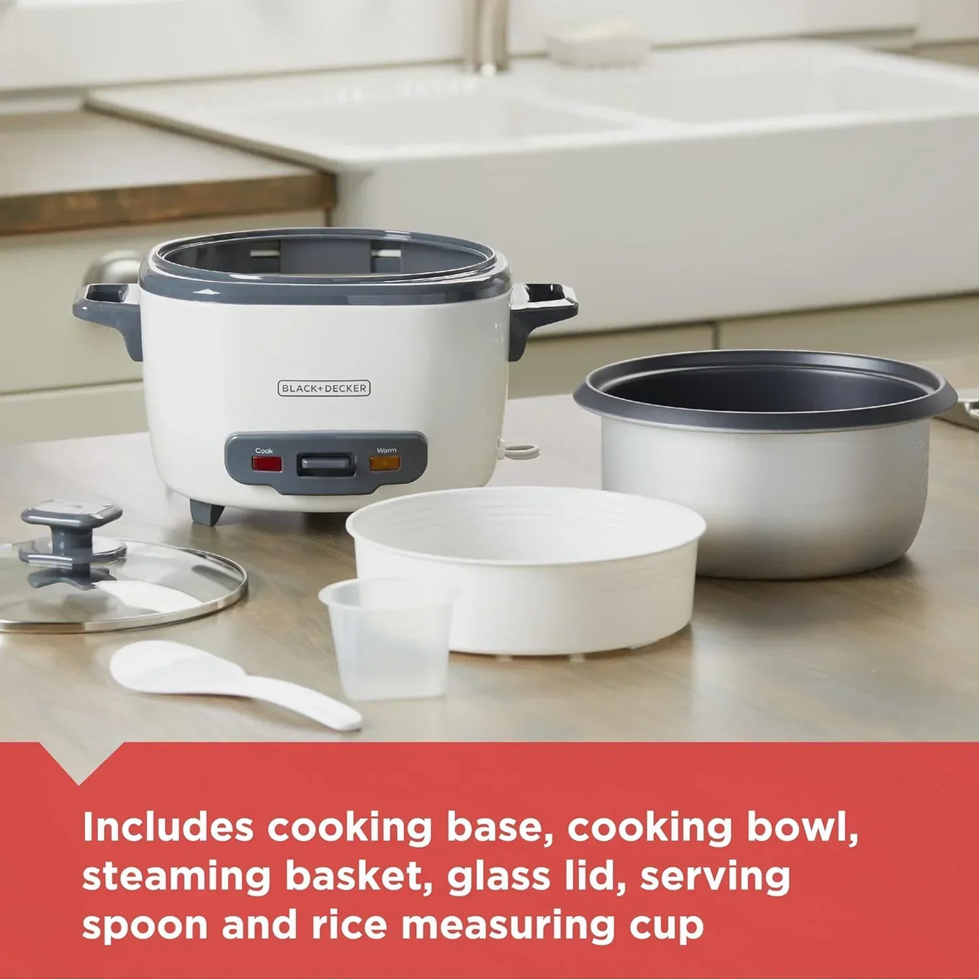 Black+Decker rice cooker with steaming basket, glass lid, and serving accessories on kitchen counter