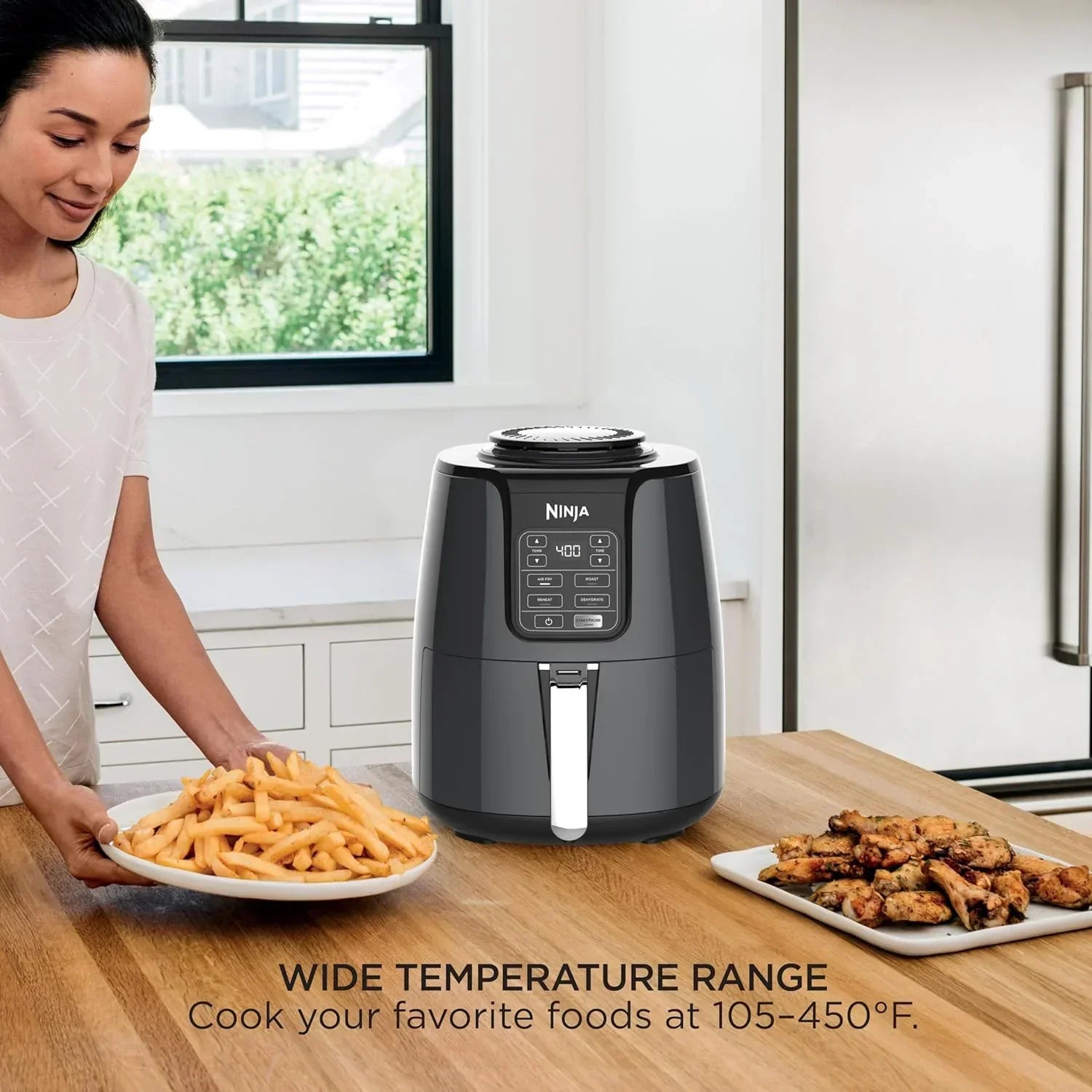 Ninja air fryer with crispy fries and chicken wings on kitchen counter