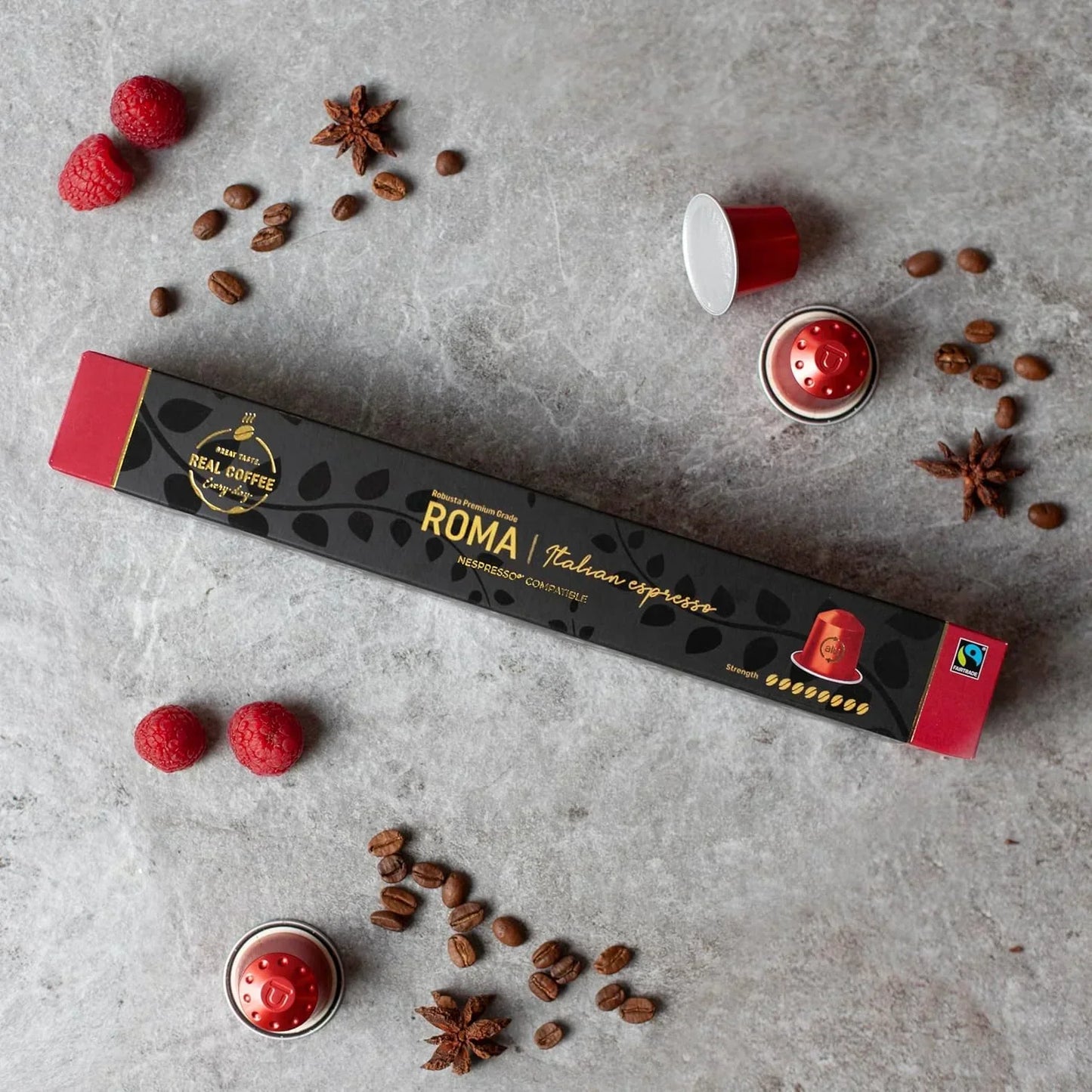 Roma Italian espresso coffee pods, Nespresso compatible, with raspberries, star anise, and coffee beans on gray surface