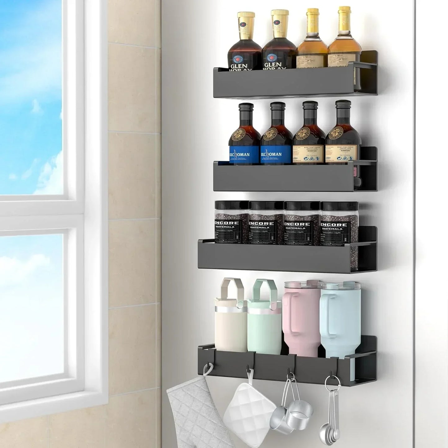 Wall-mounted black kitchen storage organizer holding bottles, jars, cups, and hanging utensils