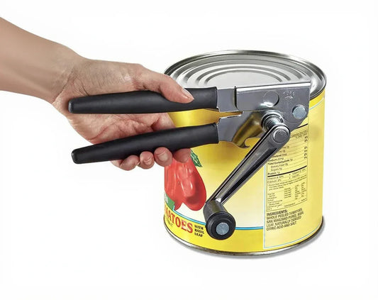 Hand using black-handled can opener on a yellow tomato can for easy kitchen prep