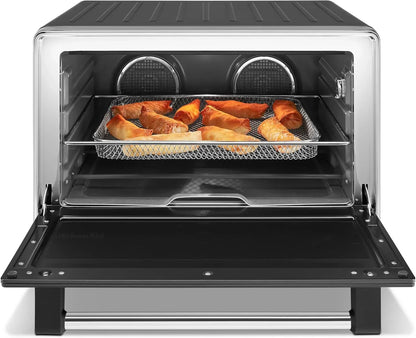 KitchenAid air fryer oven with crispy egg rolls on mesh tray, stainless steel interior, open door view
