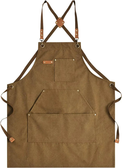 Brown canvas kitchen apron with leather straps, cross-back design, and multiple pockets for cooking and baking.