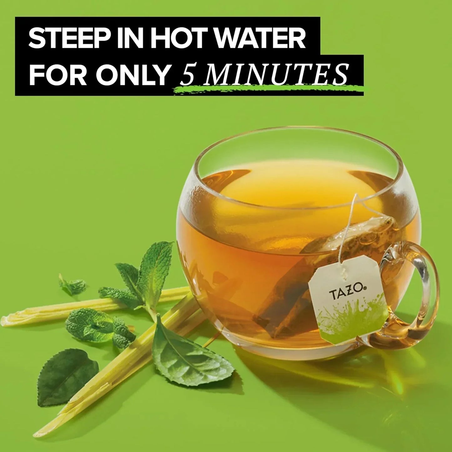 Tazo tea bag steeping in glass mug with fresh mint, quick 5-minute brew on green background