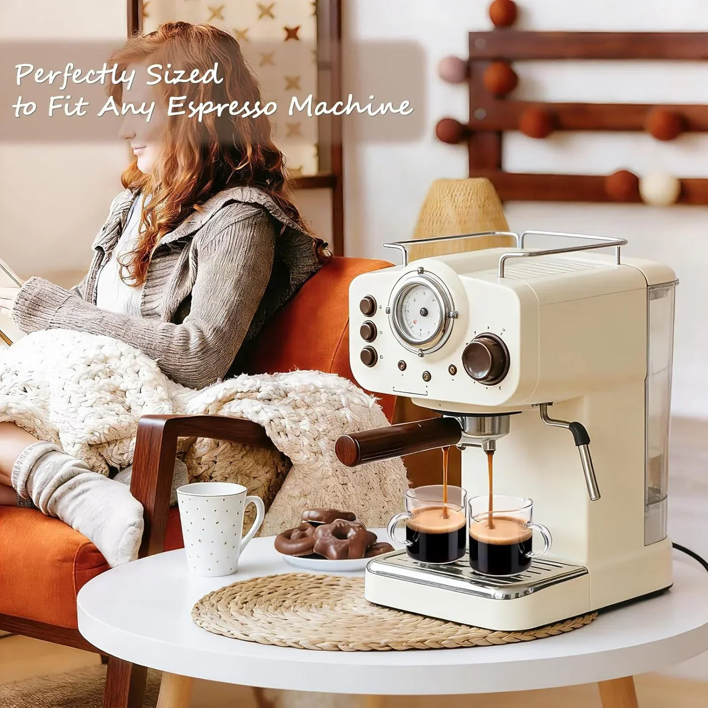 Cream espresso machine brewing coffee into glass cups beside cozy living room chair and snacks