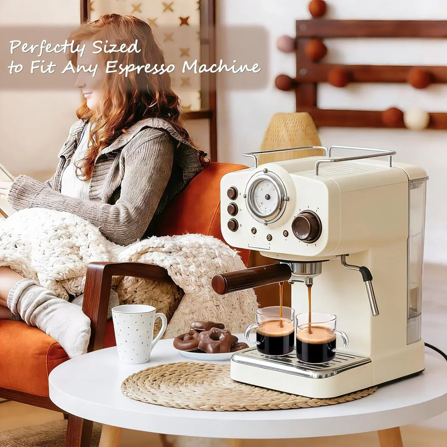 Cream espresso machine brewing coffee into glass cups beside cozy living room chair and snacks