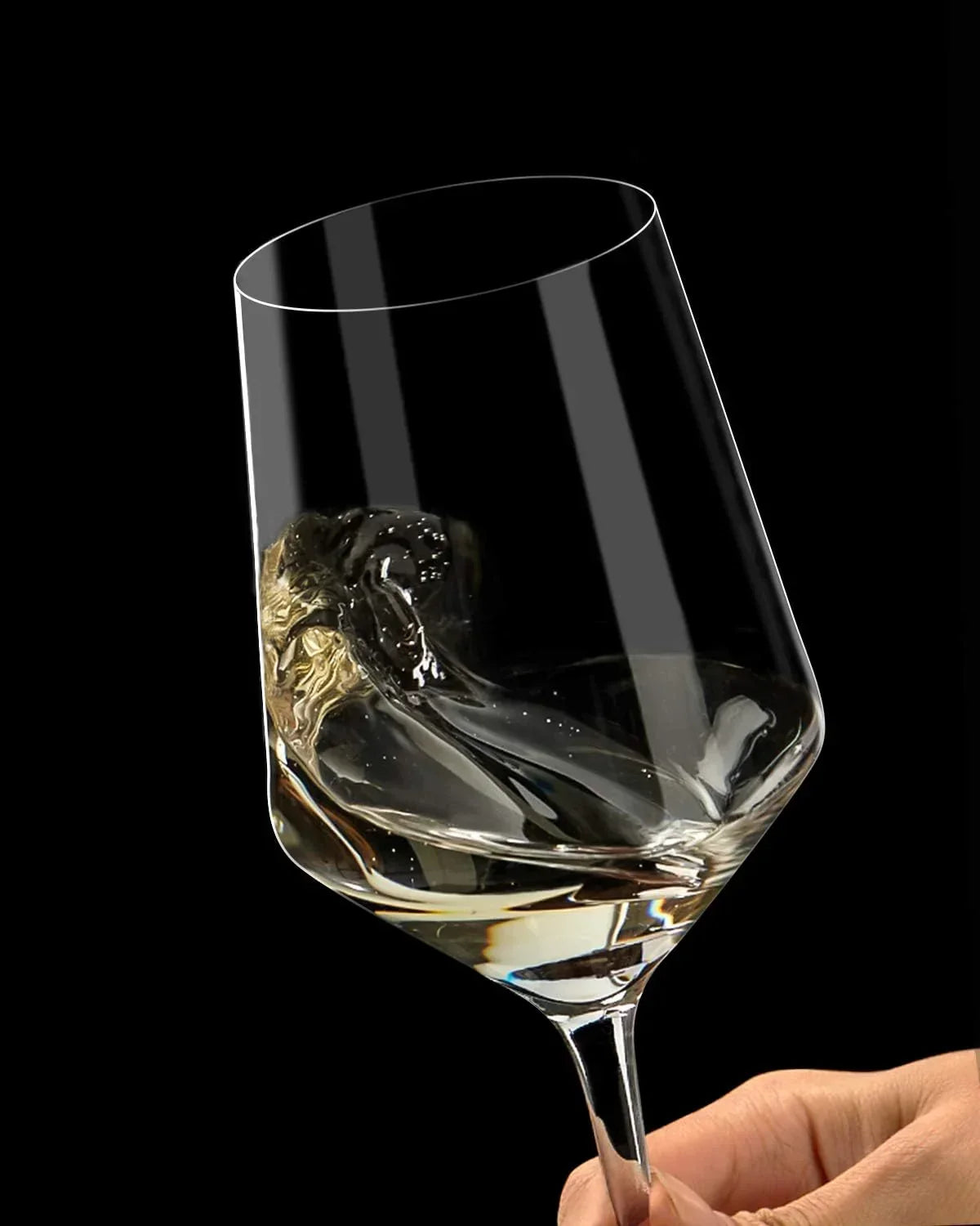 Elegant wine glass with swirling white wine, held against a black background for dramatic effect.