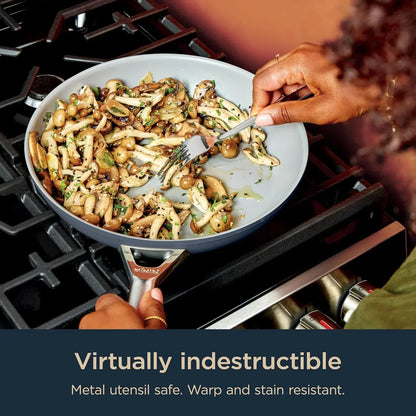 Nonstick frying pan cooking mushrooms on gas stove, metal utensil safe and stain resistant