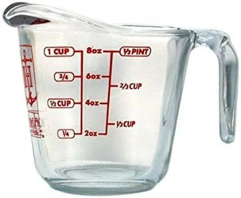 Clear glass measuring cup with red measurement markings for cups, ounces, and pints, ideal for baking and cooking.