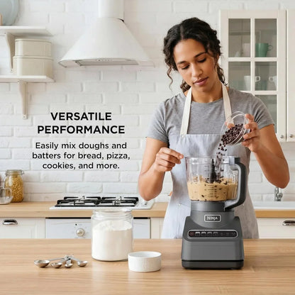 Woman adding chocolate chips to Ninja blender for cookie dough in bright kitchen