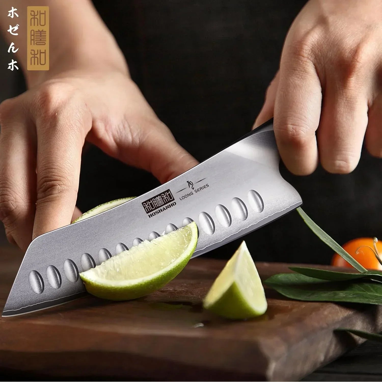 Santoku kitchen knife slicing a lime on a wooden cutting board, close-up