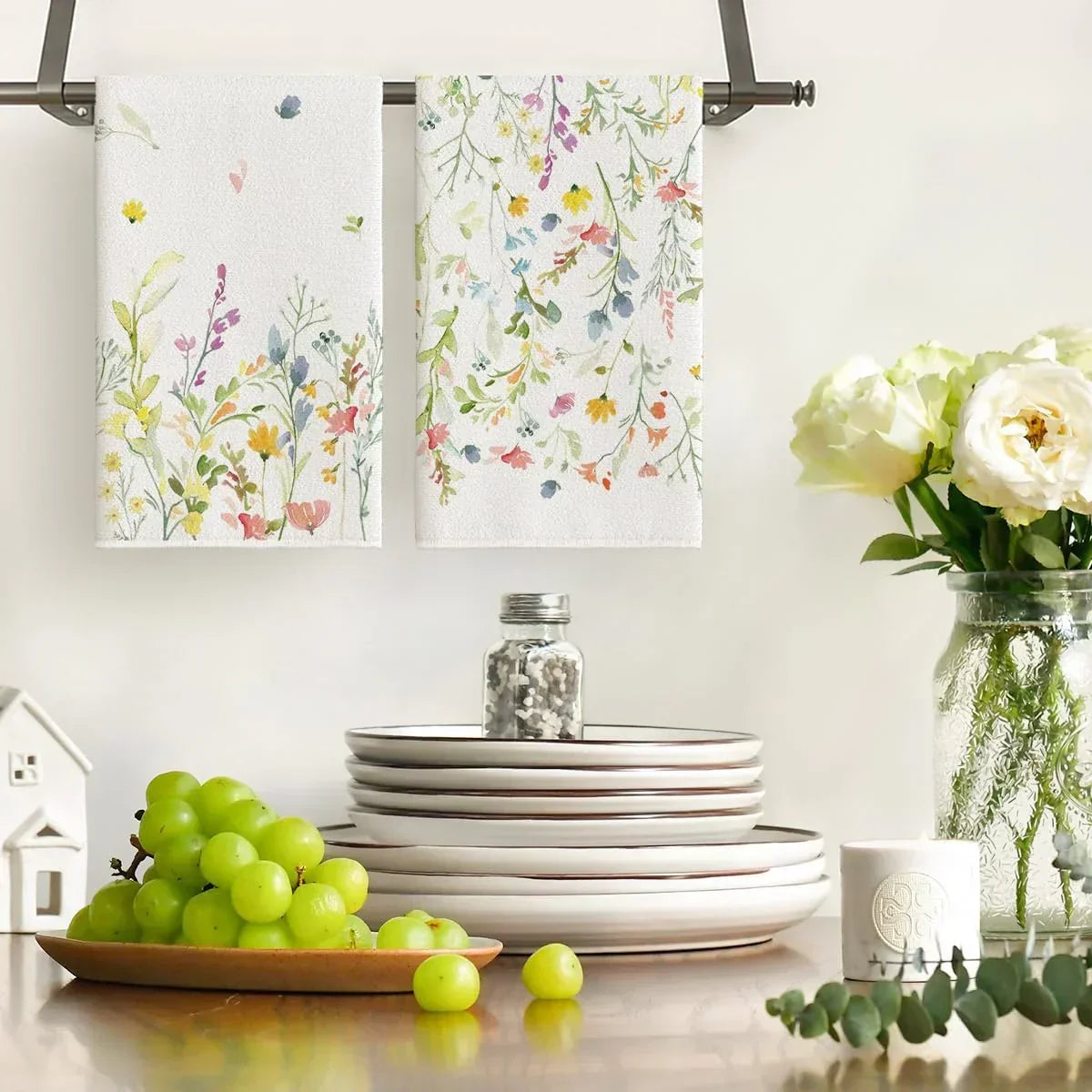 Floral kitchen towels hanging on rack with plates, grapes, and flowers for cozy cooking and serving