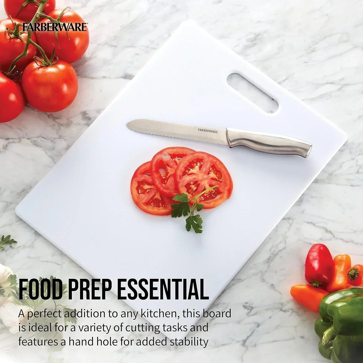 White Farberware cutting board with serrated knife, sliced tomatoes, and fresh peppers on marble countertop