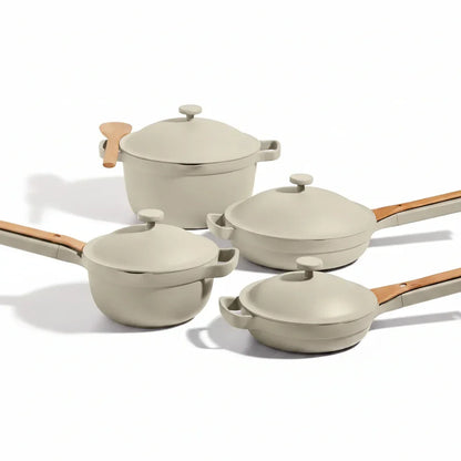 Beige ceramic cookware set with wooden handles and lids, ideal for everyday cooking and kitchen organization
