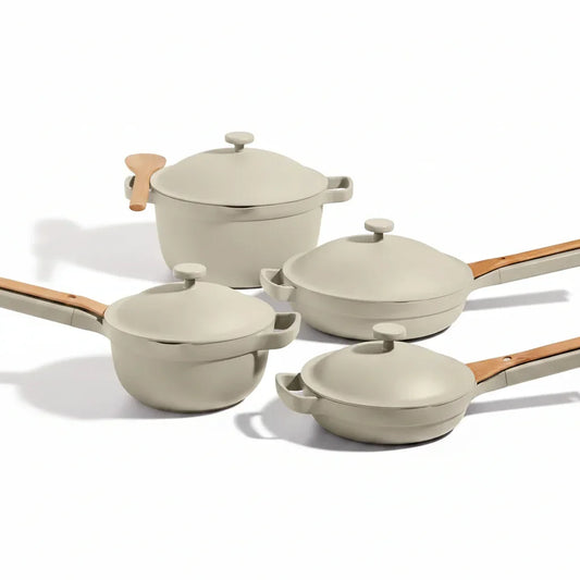 Beige ceramic cookware set with wooden handles and lids, ideal for everyday cooking and kitchen organization