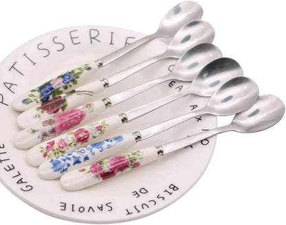 Floral ceramic-handled teaspoons on a French patisserie plate, perfect for tea or dessert serving.