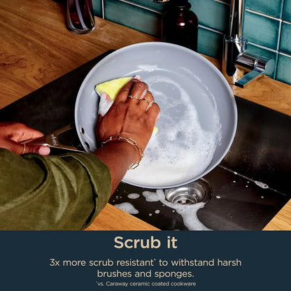 Hand scrubbing nonstick frying pan with sponge in soapy sink, showcasing durable ceramic cookware easy to clean