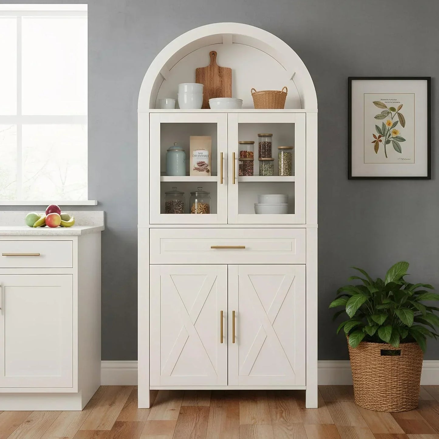 White kitchen storage cabinet with arched top, glass doors, and gold handles for organized cookware and pantry items