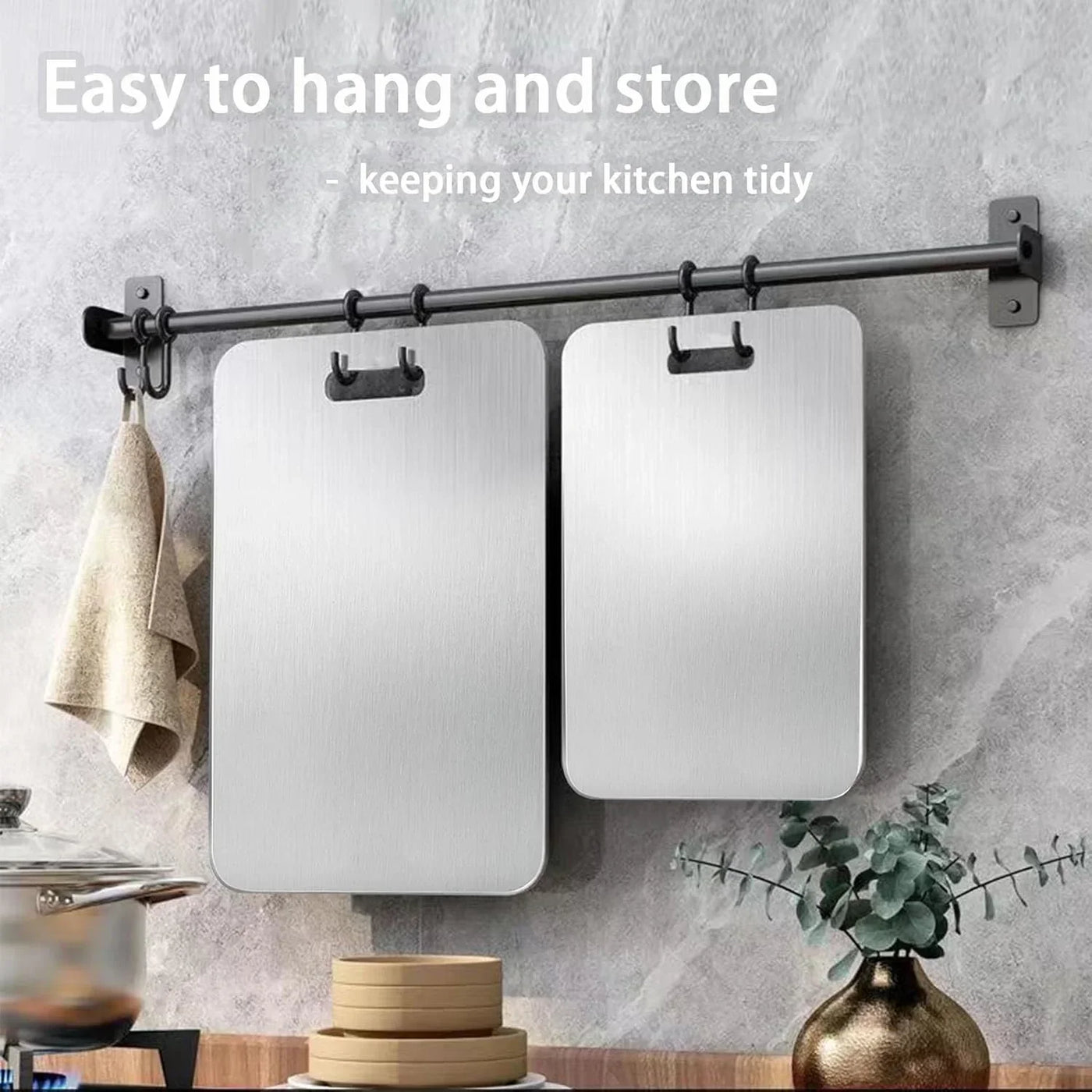 Stainless steel cutting boards hanging on wall rack for tidy kitchen storage